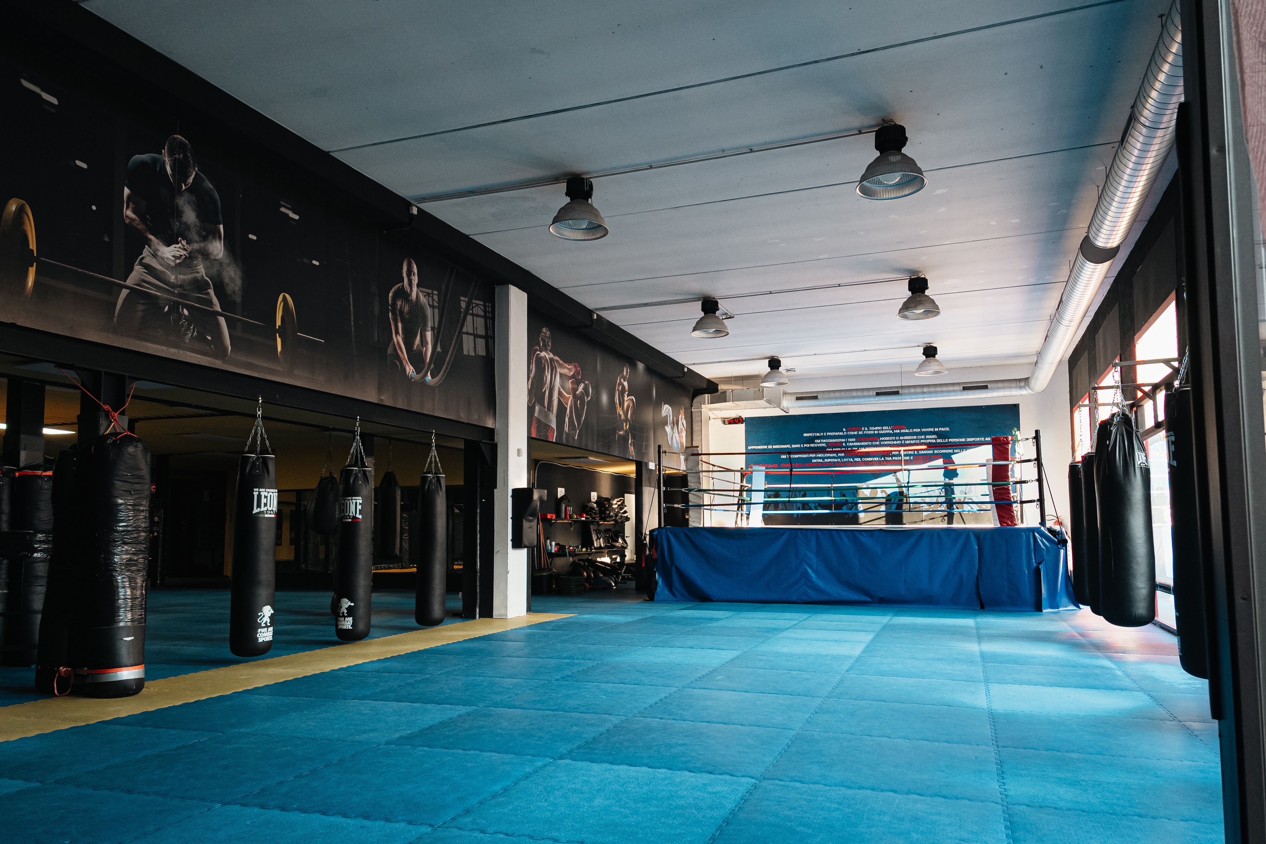 Ring boxe palestra Monza — sala con ring professionale, sacchi Leone e tatami per corsi kickboxing e shooting